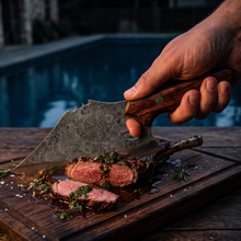 Mastodon 7.5 inch cleaver knife cutting steak outdoors, hammer textured blade in use