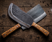 Grizzly hand forged cleaver shown with a second large cleaver for chopping